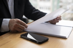 business-man-holding-glossy-paper-scaled